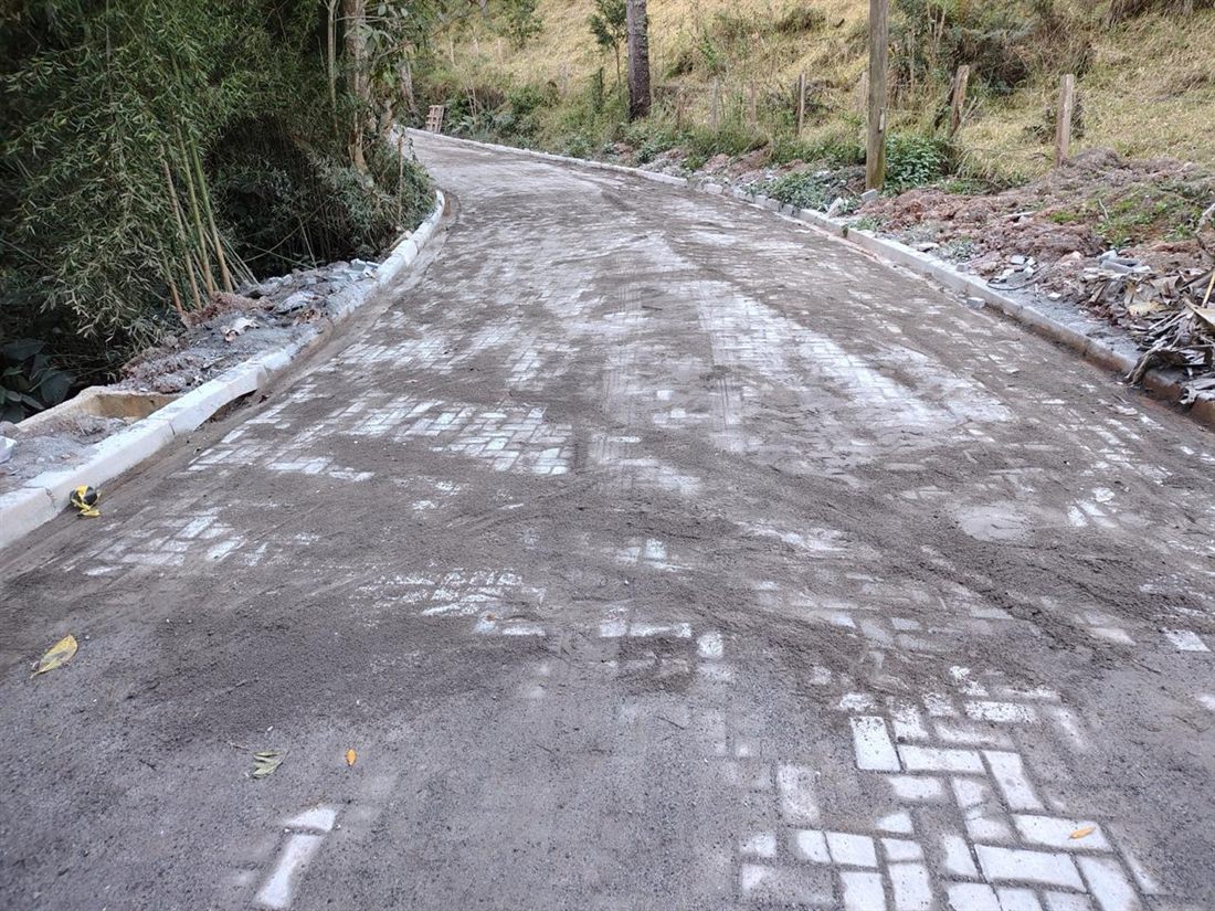 Estrada pavimentada com bloquetes, guias laterais e rejunte de areia